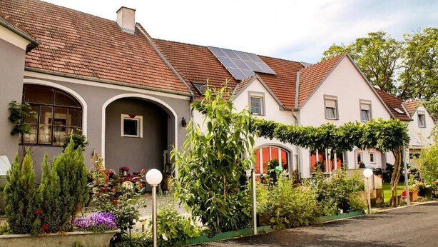 A residential street with houses, a garden, and a solar panel. - Pension Haus Marianne (Nußdorf ob der Traisen)