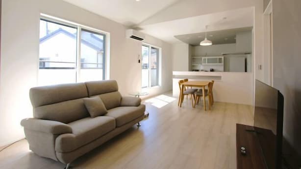 Een moderne woonkamer met een bank, een eettafel en een televisie.