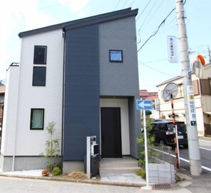A modern two-story building with a parking sign indicating availability. - New 2-story house! 2 minutes to station, parking, easy Disneyland access, near restaurants & shops (Chiba)