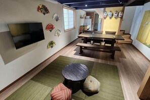 A room with a flat-screen TV, a wooden dining table, and a sofa with cushions. - [Mina's LanternHouse] 1 house (3 bedrooms/8 beds/2 parking lots) (Takayama)