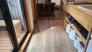 Une cuisine moderne avec un plancher en bois, un coin repas avec des chaises et des bacs de rangement.