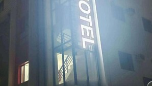Une enseigne d’hôtel avec un escalier menant à l’entrée.