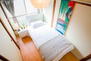 A bedroom with a bed, bedside table, lamp, and a painting on the wall. - Ikebukuro Free Pickup#Ueno 14 mins Nippori 10 mins Entire property Up to 7 guests B (Tokyo)