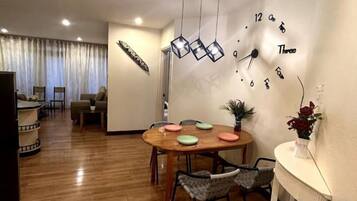 A dining area with a wooden table, chairs, and a wall clock.