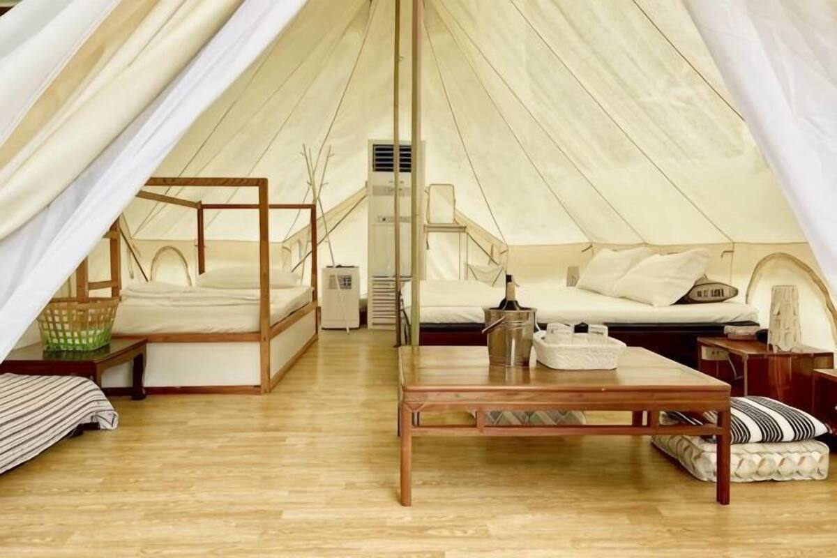 Een tent met een bed, een tafel en een stoel.