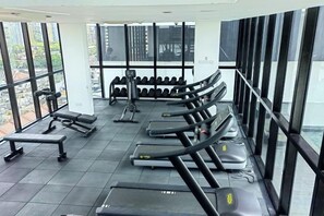 A gym with treadmills, dumbbells, and benches arranged in rows. - Leisure City NightView 2BR Urban Suites Georgetown (Jelutong)