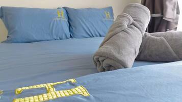 Uma cama com roupa de cama azul e uma toalha.