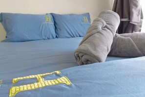 A bed with blue bedding and a towel on it. - Leisure City NightView 2BR Urban Suites Georgetown (Jelutong)