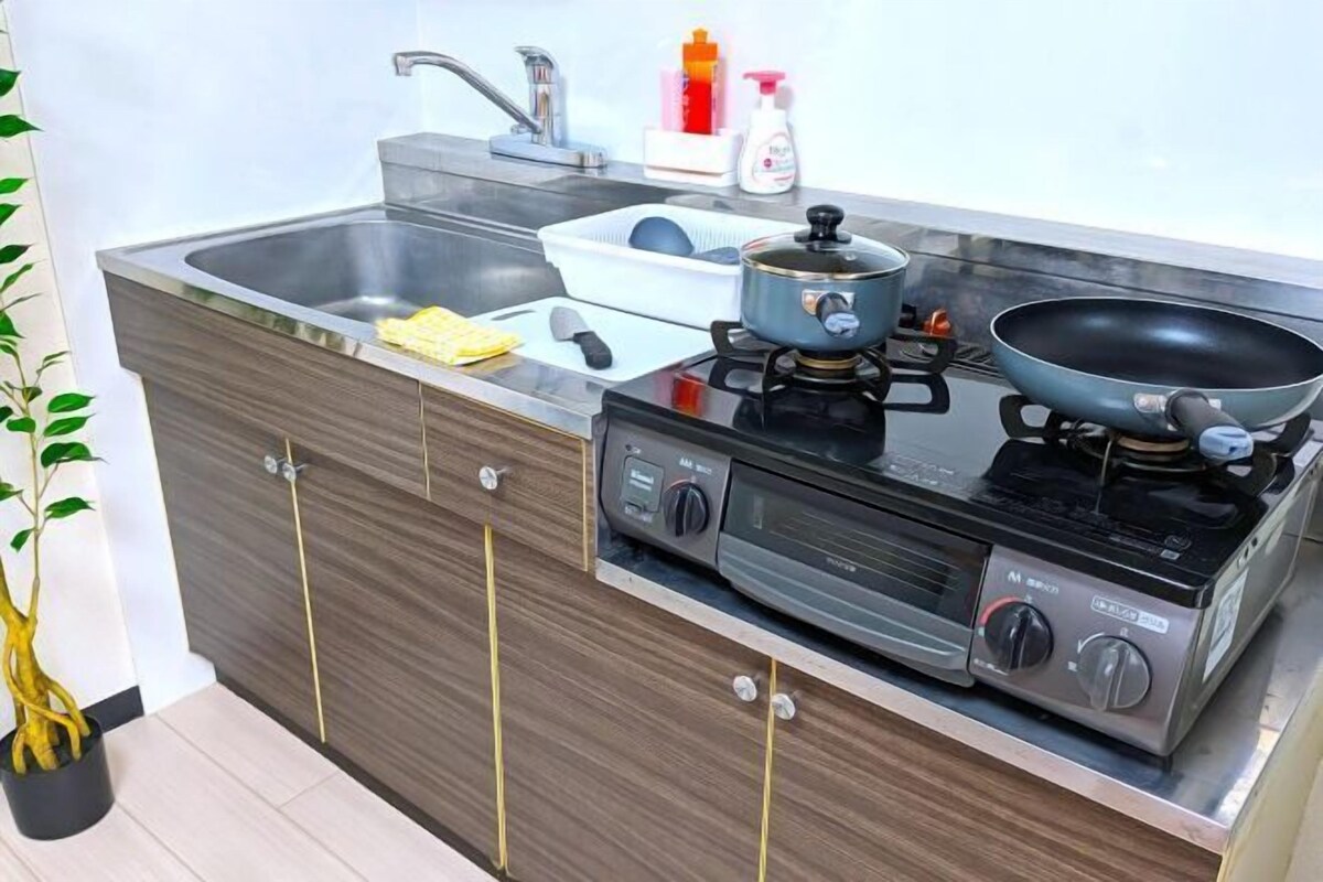 A compact kitchen with a sink, stove, and a small countertop area.