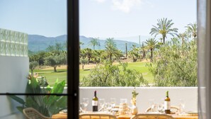 A dining area with a view of a golf course and palm trees. - Almería, Suite 344, Aralia (Vera)