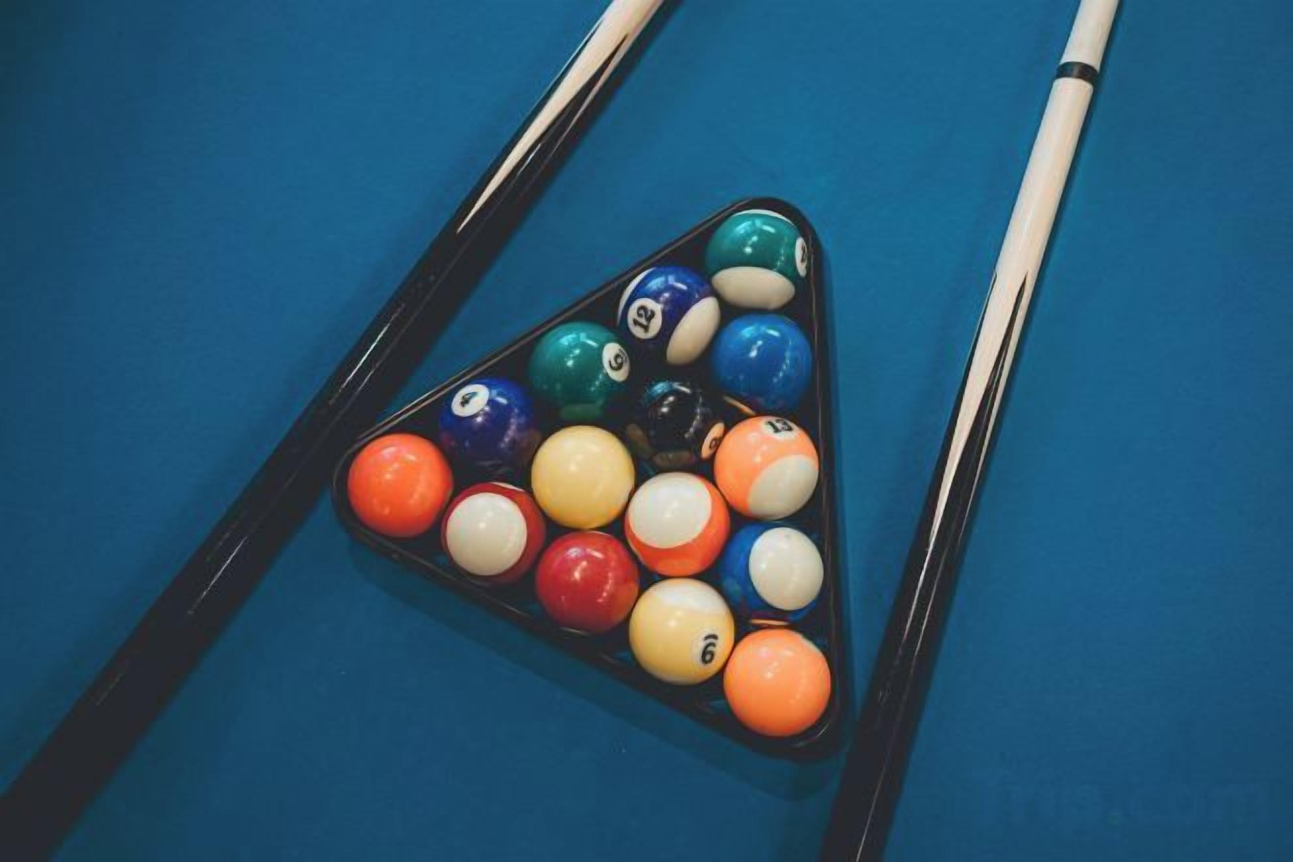Une table de billard avec un triangle servant à placer les billes.