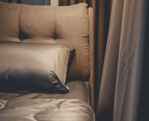 A bed with a headboard, pillows, and a blanket. - Modern Luxury Shoplot Style Sutera 3BR 10pax (Johor Bahru)