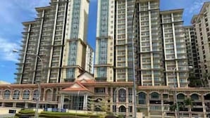 A high-rise residential building with multiple balconies and a central courtyard. - Comfy Homestay River View Kuching 4 pax (Kuching)