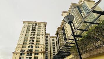 Een hoog appartementencomplex met meerdere balkons en een glazen gevel.