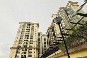 A high-rise residential building with multiple balconies and a glass facade. - Comfy Homestay River View Kuching 4 pax (Kuching)