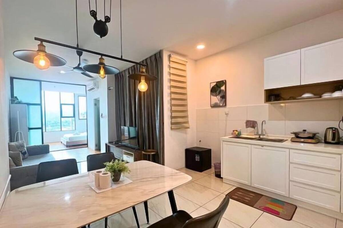 A modern kitchen with white cabinets, a dining area with a marble table, and a ceiling fan.