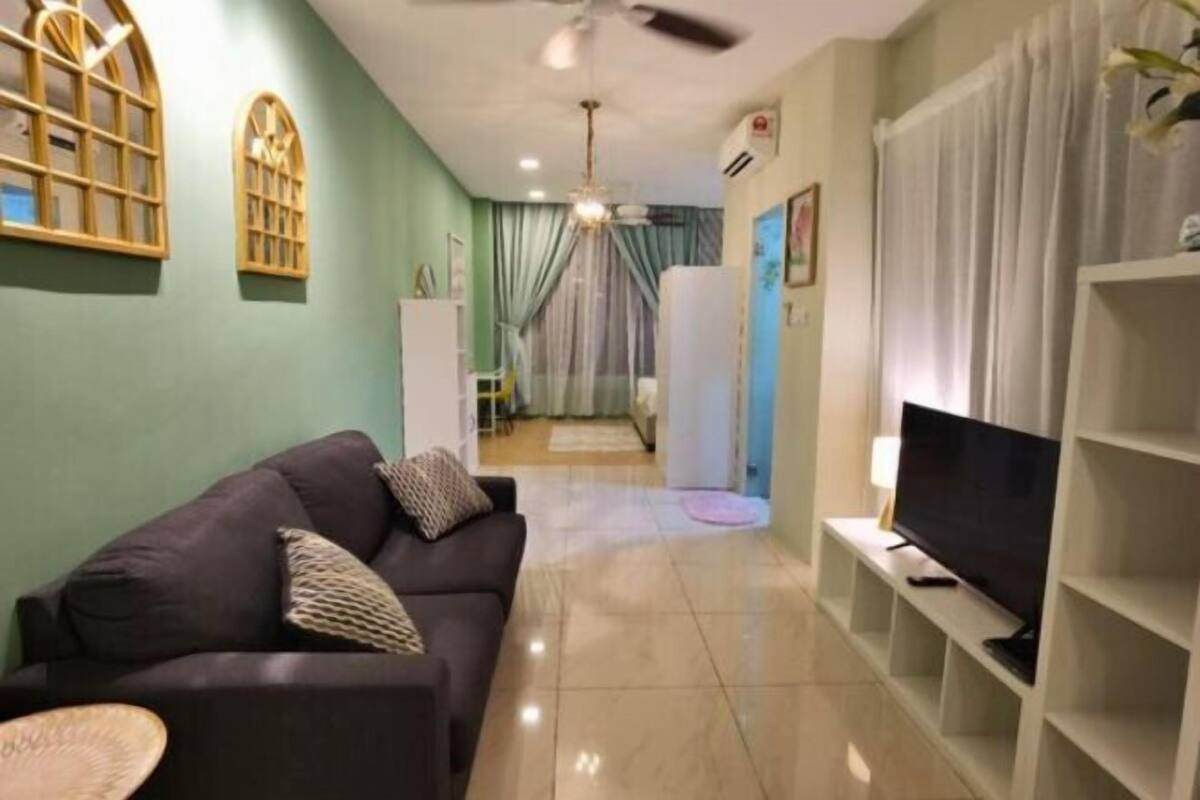 A living room with a sofa, TV, and a ceiling fan.