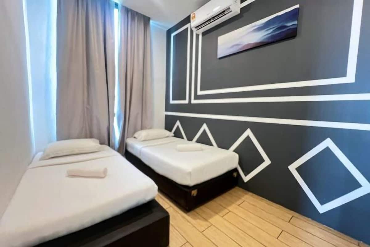 A room with two beds, a wall-mounted air conditioner, and a painting.