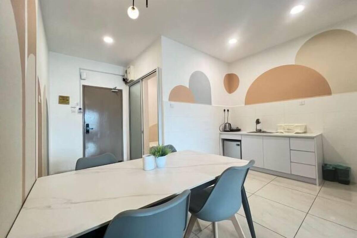 A modern kitchen with a marble countertop, a sink, and a small plant.