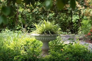 A garden with a decorative planter containing green plants.