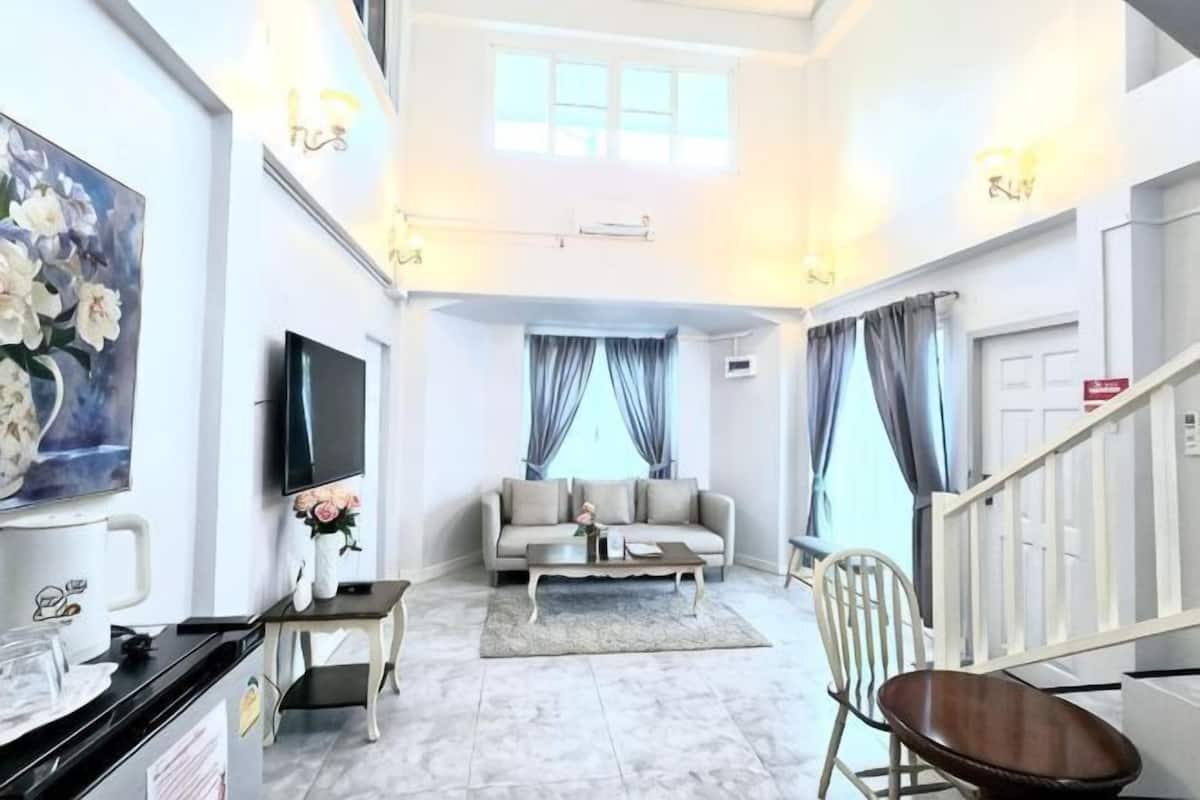 Una sala moderna con sofá, televisor y obras de arte en la pared.