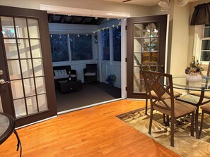 An open door leading to a room with a wooden floor, a glass table, and a chair. - Spacious Townhouse l Retreat on Pawtuckaway River (Nottingham)