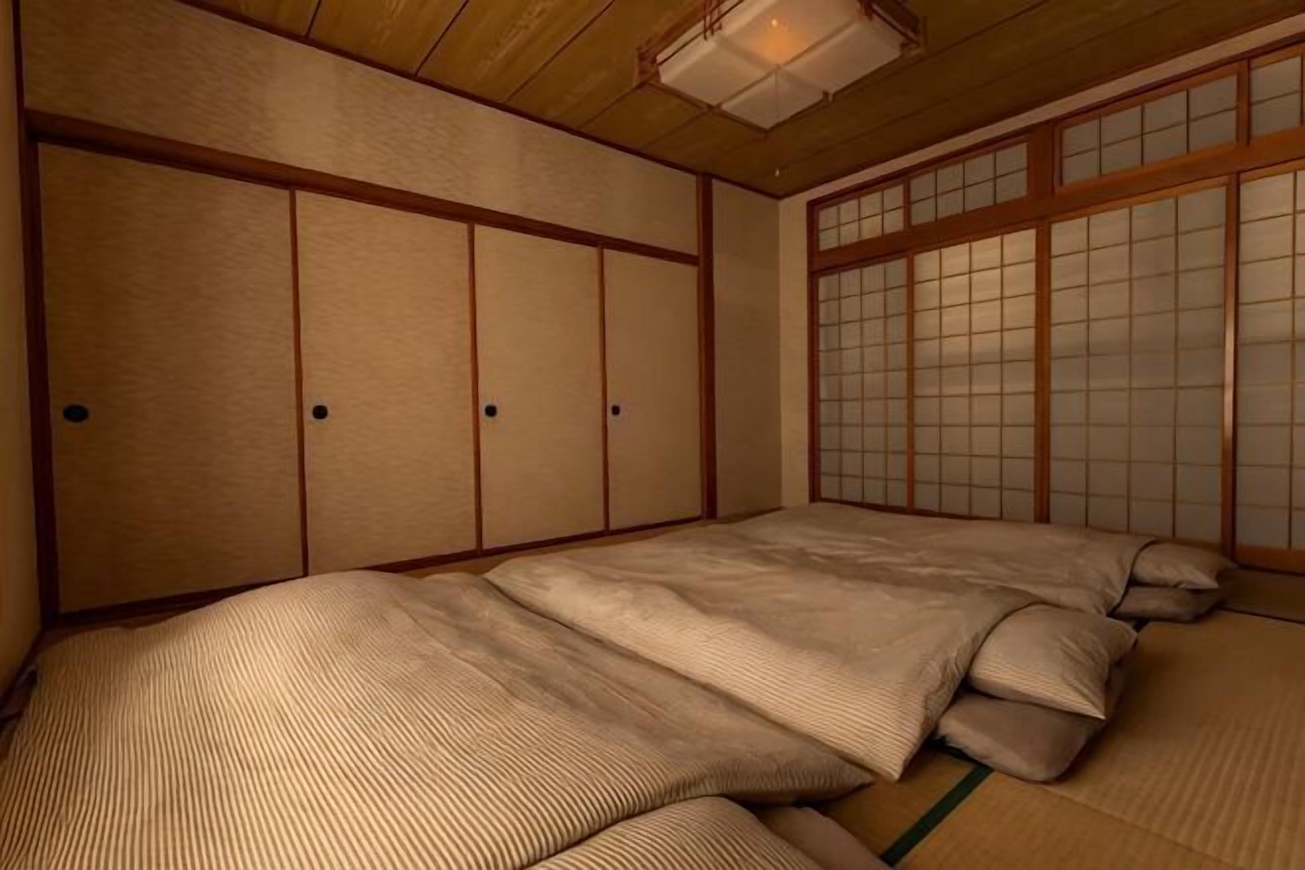 A traditional Japanese room with tatami flooring, shoji screens, and a futon bed.