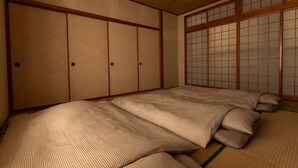 A traditional Japanese room with tatami flooring, shoji screens, and a futon bed. - Agari (Ie)
