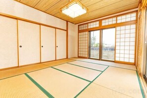 A traditional Japanese room with tatami flooring, sliding doors, and a wooden ceiling. - Agari (Ie)