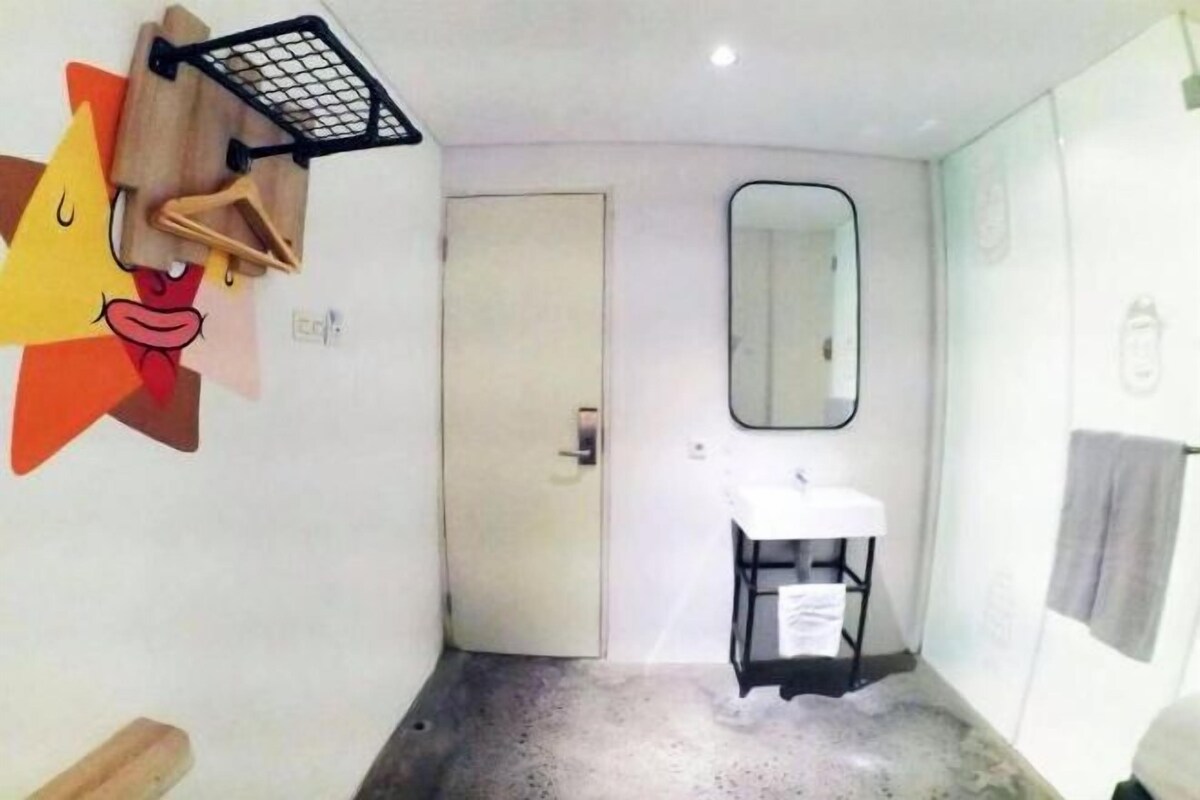 A small bathroom with a white sink, a mirror, and a towel rack.