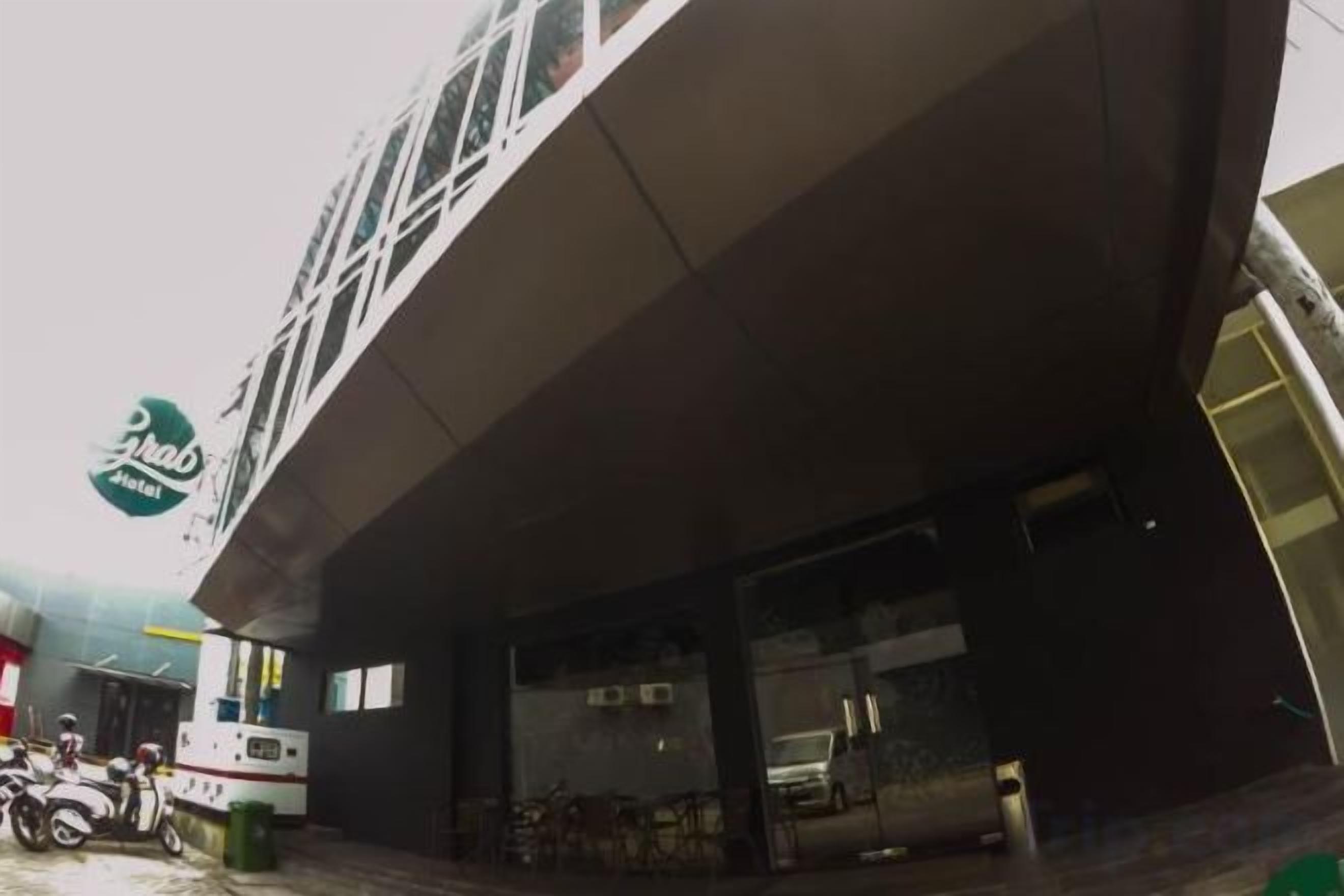 A building with a large overhang, a visible sign, and a parked scooter.