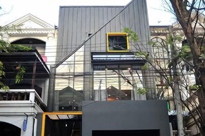 Un edificio moderno con facciata in vetro, una piccola finestra e un balcone.