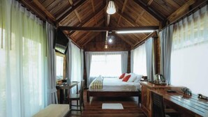 Ein Zimmer mit Holzwänden, einem Bett, einem Schreibtisch und einer Bank.