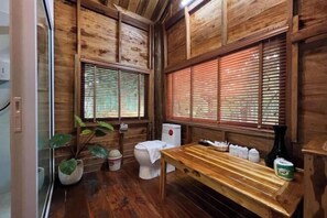 Ein Badezimmer im Holzblockhaus-Stil mit Toilette, Waschbecken und einer Holzbank.