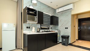 Une cuisine moderne dotée d’un four à micro-ondes encastré, d’une cuisinière et de meubles de couleur noire.