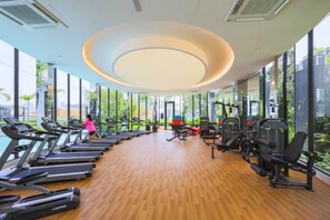 A gym with treadmills, weight machines, and a person exercising. - Trion KL by Vivid Stay (Kuala Lumpur)