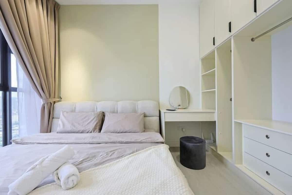 Un dormitorio moderno con cama, mesita de noche, espejo y armario.