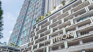 Un immeuble de grande hauteur doté de nombreux balcons et d’une enseigne « TRION » bien visible.