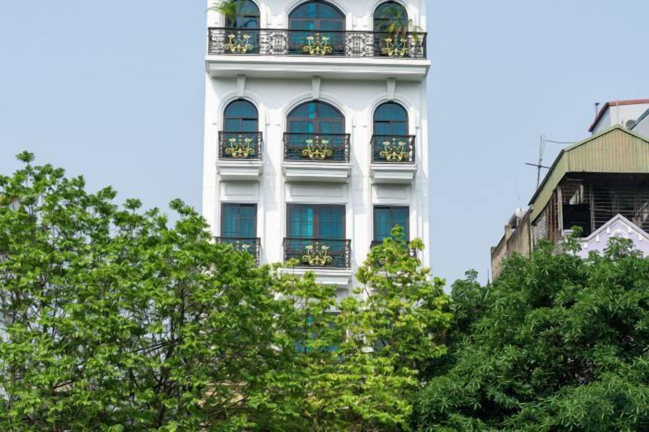 Ein mehrstöckiges Gebäude mit Balkonen, großen Fenstern und blauem Himmel.