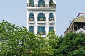 Ein mehrstöckiges Gebäude mit Balkonen, großen Fenstern und blauem Himmel.