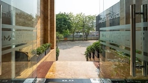 A hotel entrance with glass doors and a marble floor leading to a courtyard. - Legend Smart Hotel (Hanoi)