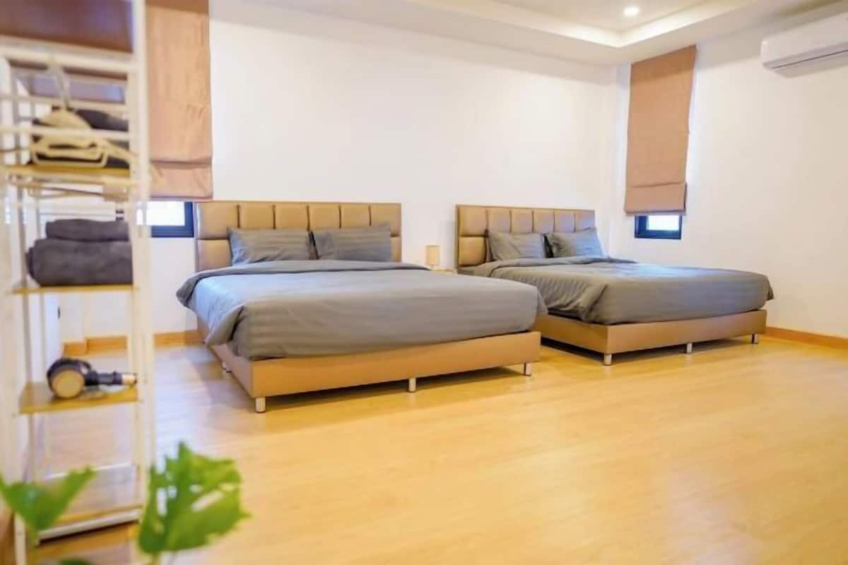 A bedroom with two beds, a wardrobe, and a shelf with items.