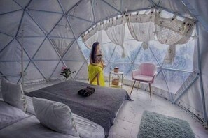 A dome-shaped tent with a bed, a chair, and a small table with a basket. - Maekhumponghill Chiangmai (Mae On)
