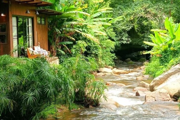 A wooden building with a glass door and a small outdoor seating area. - Maekhumponghill Chiangmai (Mae On)