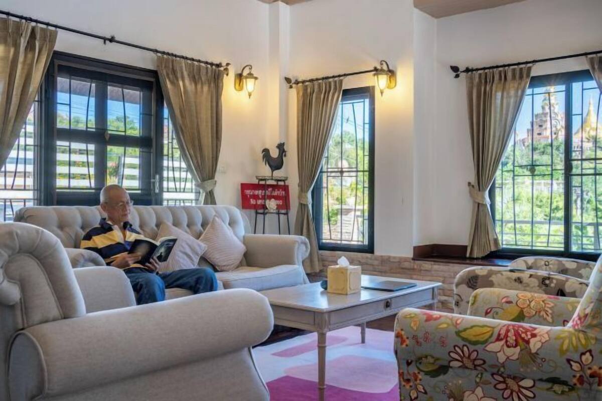 Un salón con sofá, sillones, una mesa de centro y una estatua decorativa de gallo.