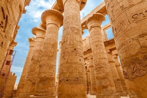 A series of large, intricately carved columns with hieroglyphs, likely part of an ancient Egyptian temple or monument. - Susan's Guest House and Tours (Luxor)