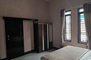 A bedroom with a bed, wardrobe, and windows. - F_one Village (Cisarua)