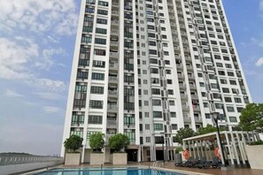 A high-rise residential building with multiple balconies, a swimming pool, and a covered outdoor area. - Bukit Indah Near Aeon and Legoland Johor with Netflix (Johor Bahru)