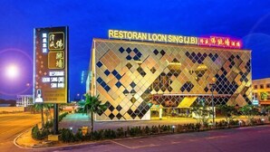 Un edificio con fachada de diseño en rombos y letrero que dice 'Restoran Loon Sing (JB)'.