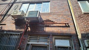 Un bâtiment en briques sur lequel est apposée une enseigne indiquant : « Trade Hope Customs & Trading Services ».